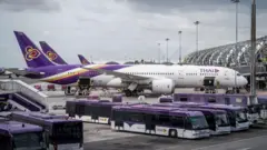 2022/08/12: A Thai Airways (TG) Airbus A330 is parked around transit buses outside a departure gate at Suvarnabhumi International Airport (BKK)