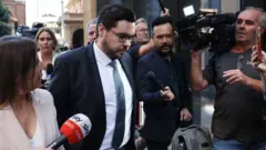 بروس لرمان هنگام ترک دادگاه