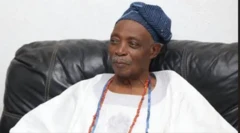 Ọba Rashidi Ladoja wọ aṣọ funfun, wọ ilẹ̀kẹ̀ sọ́rùn, ó rẹ́rìn-ín músẹ́