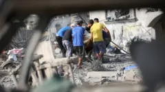 فلسطينيون يبحثون بين أنقاض منازلهم المدمرة عن أي ممتلكات يمكن استخدامها بعد غارة جوية إسرائيلية استهدفت عدة منازل في مخيم جديد شمال غرب النصيرات بقطاع غزة في 29 يوليو/تموز 2025. دُمرت عدة منازل بالكامل في الهجوم، الذي أسفر عن مقتل العديد من الفلسطينيين