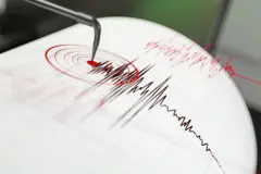 ভূমিকম্প বোঝাতে একটি কাগজের ওপর আঁকাবাঁকা রেখা টানা