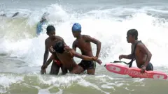 Sri Lankan lifesavers who have been trained by Japanese Red Cross officials, take part in a training exercise on a beach at Negombo