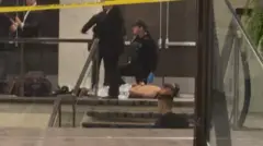 Cole Tomas Allen, sospechoso en el tiroteo durante la cena de la Asociación de Corresponsales de la Casa Blanca, yace en el suelo después de ser detenido por personal de las fuerzas del orden, en Washington, D.C., EE. UU., el 25 de abril de 2026, en esta captura de pantalla de un video. Bill Frischling/ CQ Roll Call/Handout vía REUTERS