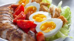 Prato com ovos cozidos, tomate, alface e carne