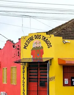 Pintura feita à mão do personagem Mestre dos Magos, da Caverna do Dragão, usando óculos escuros, embaixo da inscrição "Mestre dos Tragos", em Cruz Alta, Rio Grande do Sul