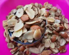 Ogbono seed wey dey inside cup with oda ogbono seeds around am wey dey inside pink bowl