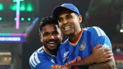 संजू सैमसन (बाएं) हंसते हुए भारत के कप्तान सूर्यकुमार यादव को गले लगाते हुए