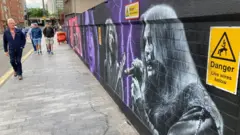 Um grande mural colorido mostrando os membros do Black Sabbath em um muro em Birmingham