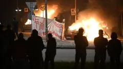 Силуэты людей на фоне пламени