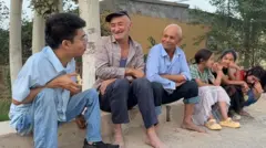 Li Chuangye conversando com moradores locais.