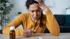መድሃኒት ፊት ለፊቷ ያስቀመጠች ሴት