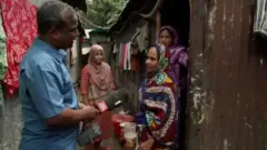 ঢাকার মিরপুরে সাকিনা বেগমের (ডানদিকে) সঙ্গে কথা বলছিলেন বিবিসির তফসীর বাবু