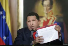 Hugo Chávez com um papel na mão falando ao microfone