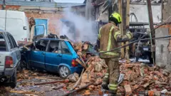 Socorristas ucranianos atuam no local onde bombas planadoras russas atingiram Kharkiv, no nordeste da Ucrânia, em 24 de outubro de 2025, em meio à invasão russa em curso. Pelo menos oito pessoas ficaram feridas após ataques russos ao distrito Industrial de Kharkiv, segundo o chefe da Administração Militar local, Oleg Synegubov.