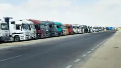 شاحنات محملة بالمساعدات الإنسانية الموجهة إلى غزة في الانتظار في العريش في شمال سيناء، في 19 مايو/أيار 2025
