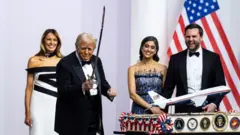 Melania Trump, yanında Donald Trump bir kılıç tutarak gülümsüyor. JD Vance ve eşi gülümsüyor
