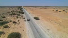 ጋሮዌን እና ቦሳሶ በሚያገናኘው መንገድ ላይ በእግራቸው የሚገዙ ስደተኞች