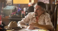 Ethan Hawke sentado en una mesa en una escena de The Lowdown.