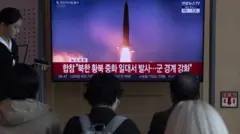 люди смотрят телерепортаж в сеуле о северокорейском ракетном запуске