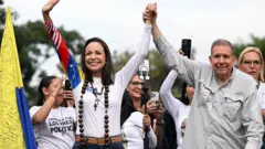 El candidato opositor Edmundo González Urrutia (der.) y la líder opositora María Corina Machado en una mitin de cierre de campaña en Caracas, el 25 de julio de 2024.
