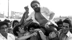 Foto em preto e branco tirada em março de 1970 de Lula sendo carregado nos braços de outros trabalhadores.