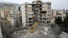 نیروهای امدادی در حال آواربرداری ساختمانی در خیابان اندرزگو تهران که در حمله آمریکا تخریب شده است