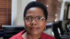 A close-up photo of Dr Phethiwe Matutu, head of Universities South Africa. She is wearing glasses and has short, cropped hair