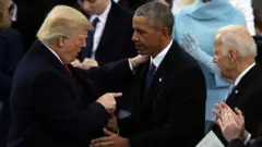O ex-presidente americano Barack Obama e o então vice-presidente Joe Biden cumprimentam o presidente Donald Trump após sua posse no Capitólio para o primeiro mandato, em 20 de janeiro de 2017, em Washington DC.