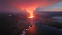 La lava ardiendo ilumina el pueblo de Grindavick en Islandia.