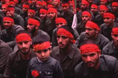Miembros del Cuerpo de la Guardia Revolucionaria Islámica (CGRI) junto a un niño en una demostración en Teherán durante la guerra de Iran-Irak.
