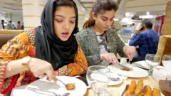 ਕੁੜੀਆਂ ਭੋਜਨ ਖਾਂਦੀਆਂ ਹੋਈਆਂ
