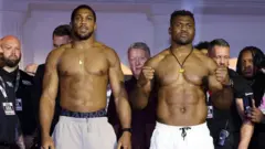 Anthony Joshua and Francis Ngannou pose for di weigh in