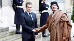 نیکولای سارکوزی در حال دست دادن با معمر قذافی