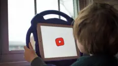Criança de costas assiste ao Youtube em um tablet