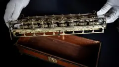 Mãos segurando o mecanismo da pascalina