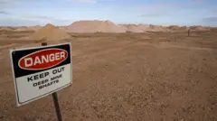 Placa em área desértica alertando sobre perigo