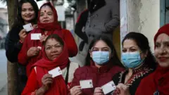 मतदाता परिचयपत्र देखाउँदै महिला मतदाताहरू