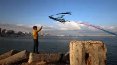 طفل فلسطيني نازح يطلق طائرة ورقية خارج خيمة لعائلته في مدينة غزة، في 13 أبريل/نيسان 2026.