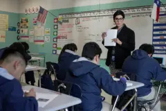 Una maestra y sus alumnos en un salón de clase.
