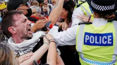 Участник демонстрации кричит на женщину в полицейской форме