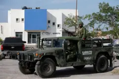 Carro militar com soldado e arma no topo