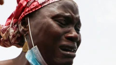 Une femme qui pleure, un masque facial attaché à sa mâchoire.