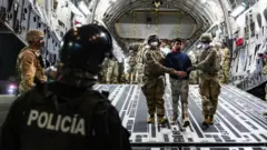 Personal militar estadounidense a un grupo de venezolanos deportados por EE.UU. al Centro de Reclusión del Terrorismo (Cecot) de El Salvador.