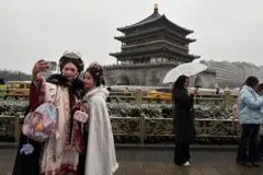 Hai người phụ nữ trong trang phục truyền thống đang chụp hình ở Tháp chuông Tây An, địa điểm du lịch nổi tiếng ở tỉnh Thiểm Tây, Trung Quốc