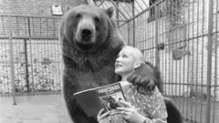 Maggie leyéndole un libro a Hércules. 