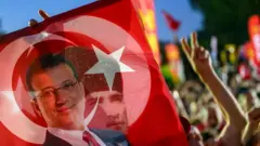 Türk bayrağının arkasından görünen Ekrem İmamoğlu posteri