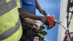 Kenyan fuel attendant selling fuel