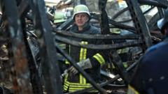ロシアの空爆で出火した商業施設で作業する救助隊員