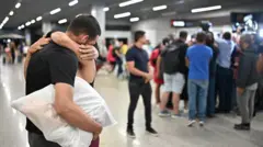 Homem abraça mulher em aeroporto de Confins em 25 de janeiro de 2024
