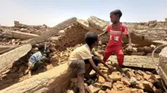 أطفال يلعبون وسط الركام